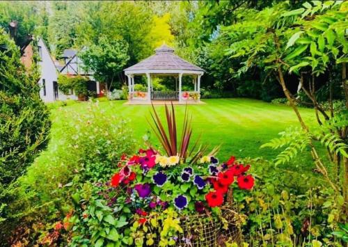 a gazebo in the middle of a yard with flowers at The Stanwick Hotel in Stanwick