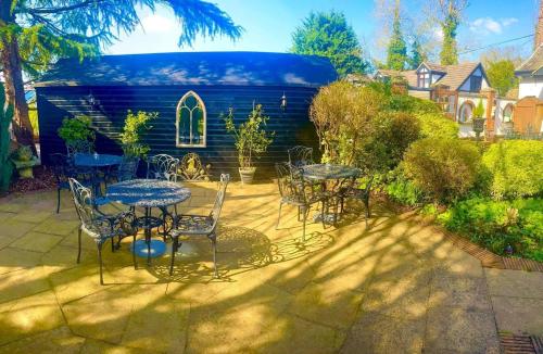 a patio with tables and chairs and a blue house at The Stanwick Hotel in Stanwick