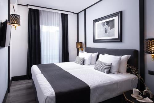 a bedroom with a large bed and a window at Athenian Riviera Hotel& Suites in Athens
