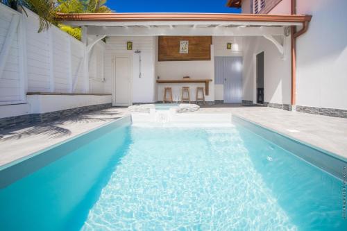 a swimming pool with blue water in a house at Villa 2 chambres, Jacuzzi et Piscine in Maximin