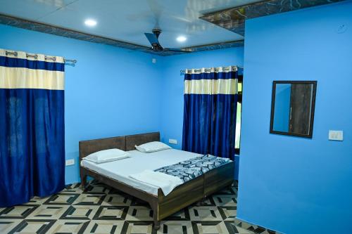 a blue bedroom with a bed and blue walls at Geeta Ji Home Stay in Rudraprayāg