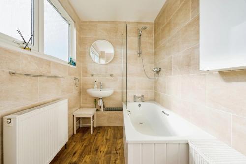 un baño con bañera y lavabo en Sunnyside, en Seaview
