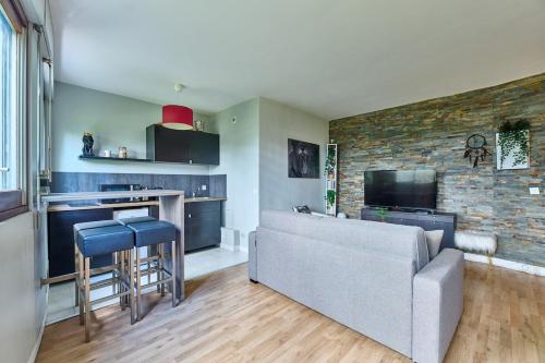 un salon avec un canapé et une cuisine avec un bar dans l'établissement Parc des Expositions et Tour Eiffel, à Paris