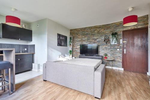 un salon avec un canapé et une télévision à écran plat dans l'établissement Parc des Expositions et Tour Eiffel, à Paris