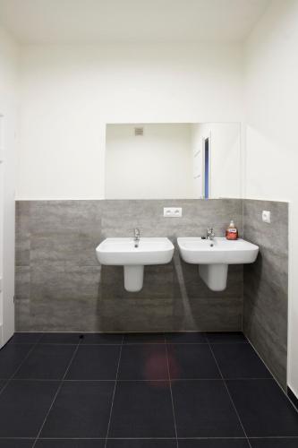 a bathroom with two sinks and a mirror at Hostel Centrum in Września