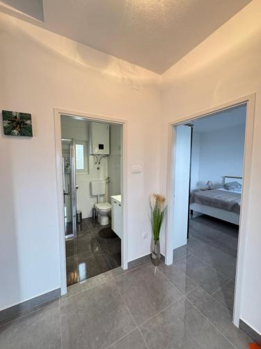 a room with a bathroom and a bedroom with a bed at ANKA - apartment by the sea in Kali