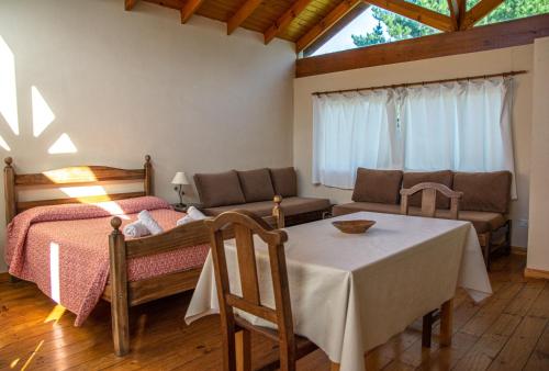 a bedroom with a bed and a table and a couch at Shalom Hospedaje in Tandil