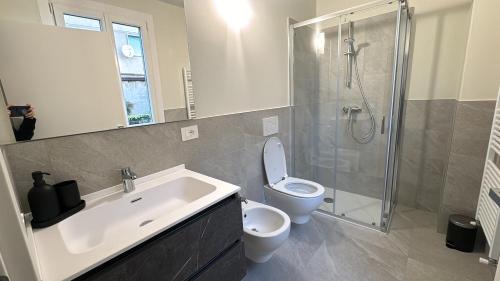 a bathroom with a sink and a toilet and a shower at Appartamento Rita in Pisogne