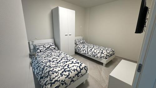 a room with two beds and a cabinet at Appartamento Rita in Pisogne