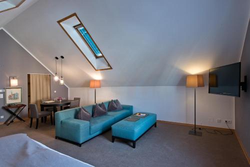 a living room with a blue couch and a table at Hotel Forstinger - Boutique Hotel Schärding in Schärding