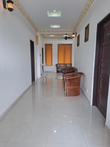 a room with a hallway with chairs and a door at The Lodge in Kuala Kerai