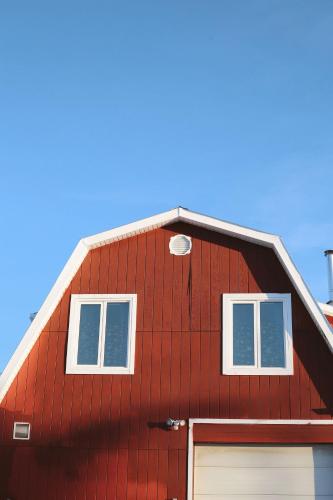a red barn with two windows and a garage at The Big Red Barn in Whitehorse