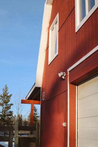 a red building with a garage door and a window at The Big Red Barn in Whitehorse