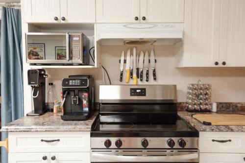 a kitchen with white cabinets and a stove top oven at The Big Red Barn in Whitehorse