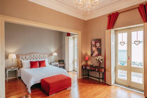 a bedroom with a bed and a red ottoman at Vintage Beach House in Matosinhos