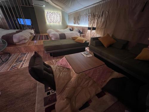 a living room with a couch and a couch and a table at RISE BEACH Okumatsushima in Higashimatsushima