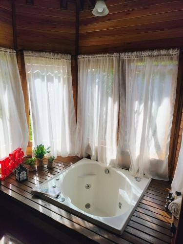 a bath tub in a room with windows at Sitio Vida in Aguas Mornas