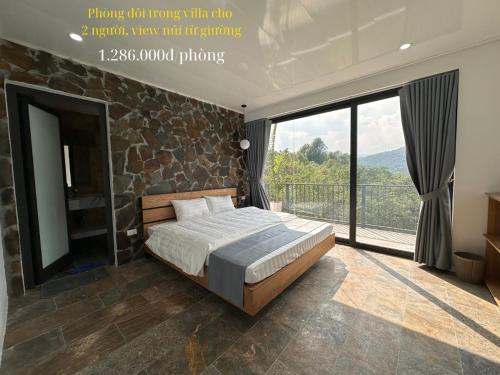 a bedroom with a bed and a large window at Ba Villa - Nhà của Hạnh Phúc in Ba Vì