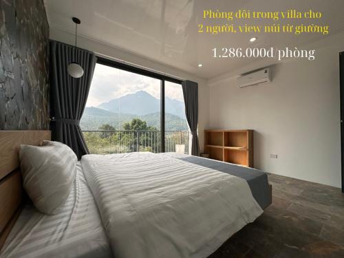 a bedroom with a large bed with a large window at Ba Villa - Nhà của Hạnh Phúc in Ba Vì