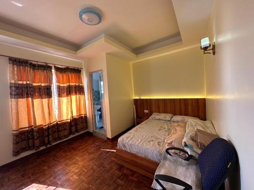 a bedroom with a bed and a chair in it at Dorje Homestay in Kathmandu