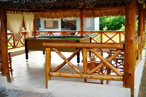 a ping pong table in a pavilion with a pool table at Kirepwe Ecco Camp Watamu in Watamu