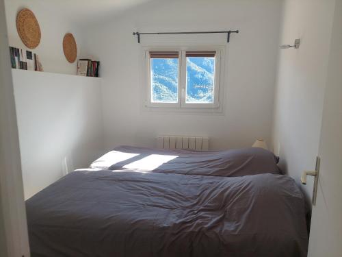 un dormitorio con una cama y una ventana en Lavande 3ème étage, en Le Mas