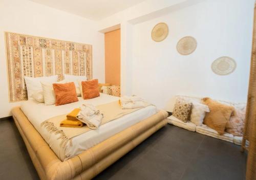 a bedroom with a large bed with orange pillows at Calya Family Home in Brussels - 4 Bedrooms in Sint-Pieters-Leeuw