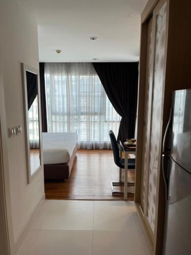 バンコクにあるApartment in Central Sukhumvitのベッドと椅子と窓のある寝室