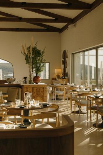 a dining room with tables and chairs and windows at Viceroy at Ombria Algarve in Loulé
