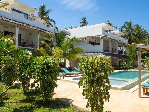 a villa with a swimming pool and a resort at Pingwe Beach Apartments in Pingwe