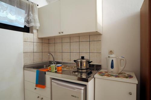 a small kitchen with a stove and a sink at Ferienhaus Elena in Agios Georgios