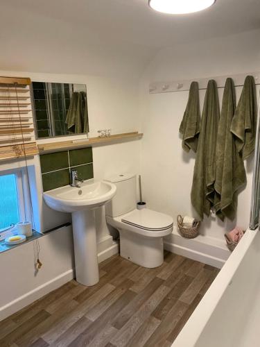 a white bathroom with a sink and a toilet at The Cottage in Sulgrave