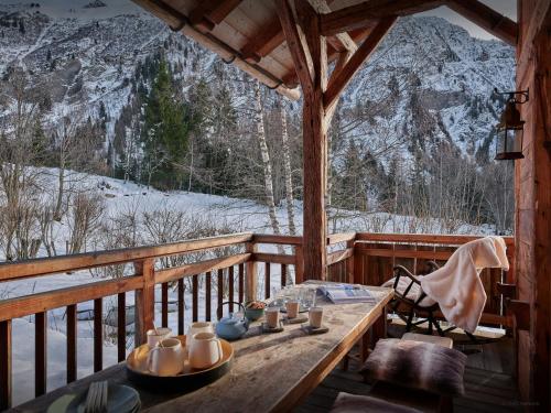 - une table sur une terrasse couverte avec vue sur la montagne dans l'établissement Chalet La Chandelle - OVO Network, à Bionnassay