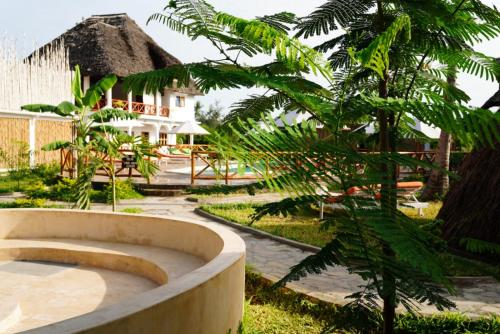 a garden with a bath tub next to a house at Kirepwe Ecco Camp Watamu in Watamu