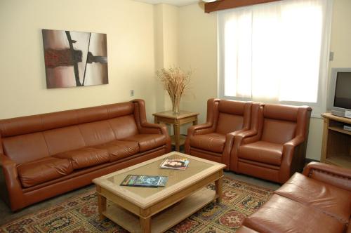 een woonkamer met 2 leren banken en een salontafel bij Hotel Porto Alegre in Porto Alegre