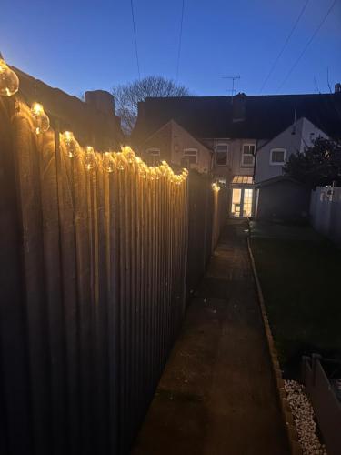 a fence with christmas lights on top of it at Waterside Stay- 3 Bed House- Sleeps 5- Parking- Fast Wifi in Burton upon Trent