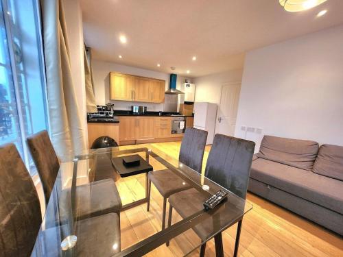 a living room with a glass table and chairs at Spacious 2-Bed Flat - Close to Tube, Sleeps 6 in London
