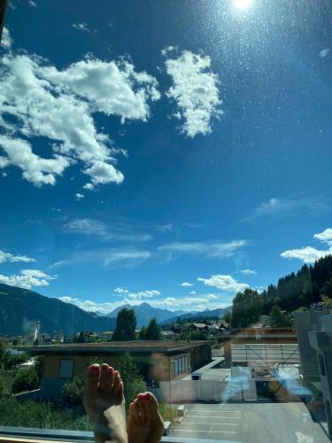 a person with their feet up on a balcony looking at the sky at Casa Vegana 4,5 Zimmer 8Pl, 3 Badezimmer in Trun