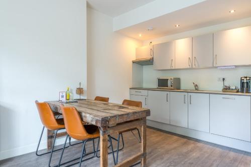 a kitchen with a wooden table and orange chairs at Hotel Oranjestaete in Nijmegen