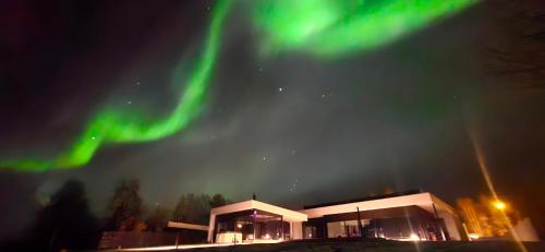 a building with the aurora in the sky at Riverside villa with sauna and jacuzzi in Rovaniemi