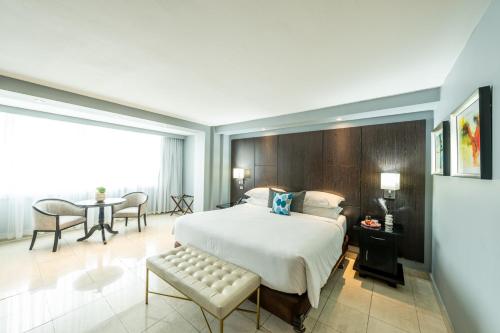 a bedroom with a bed and a table and chairs at Hotel El Panama by Faranda Grand, a member of Radisson Individuals in Panama City