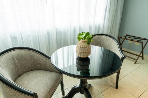 a glass table with a plant in a vase on it at Hotel El Panama by Faranda Grand, a member of Radisson Individuals in Panama City