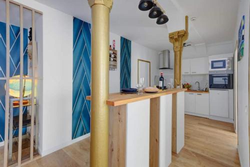 - une cuisine avec un comptoir au milieu d'une pièce dans l'établissement COSY Appartement Paris Centre, à Paris