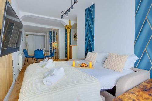 une chambre avec un grand lit blanc avec deux serviettes dans l'établissement COSY Appartement Paris Centre, à Paris