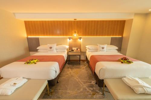 a hotel room with three beds and a table at Hotel El Panama by Faranda Grand, a member of Radisson Individuals in Panama City