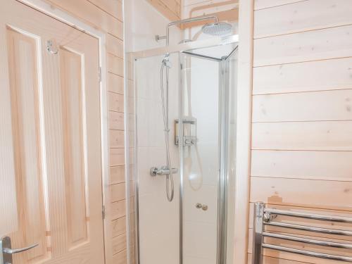una ducha con puerta de cristal en un baño en Dovestone Luxury Lodges sleeps 4 - pets welcome, en Oldham