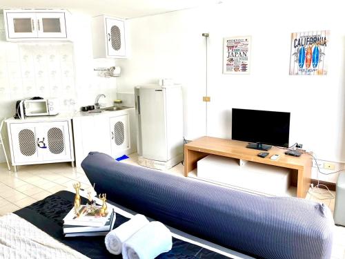 a living room with a couch and a television at Impact Arena Condo C1 by GoodRoom24 in Ban Song Hong