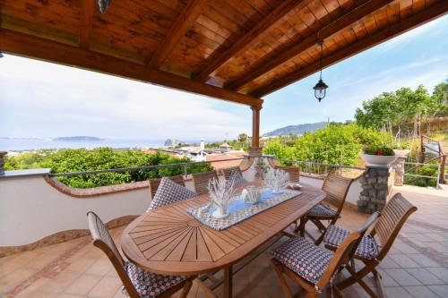 a wooden table and chairs on a patio with a view at Relais Maison de Charles in Ischia