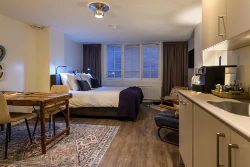 a hotel room with a bed and a kitchen with a table at Hotel Oranjestaete in Nijmegen