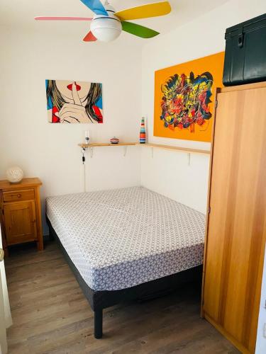 une chambre avec un lit et un ventilateur de plafond dans l'établissement T3 terrasse et piscine, au Barcarès